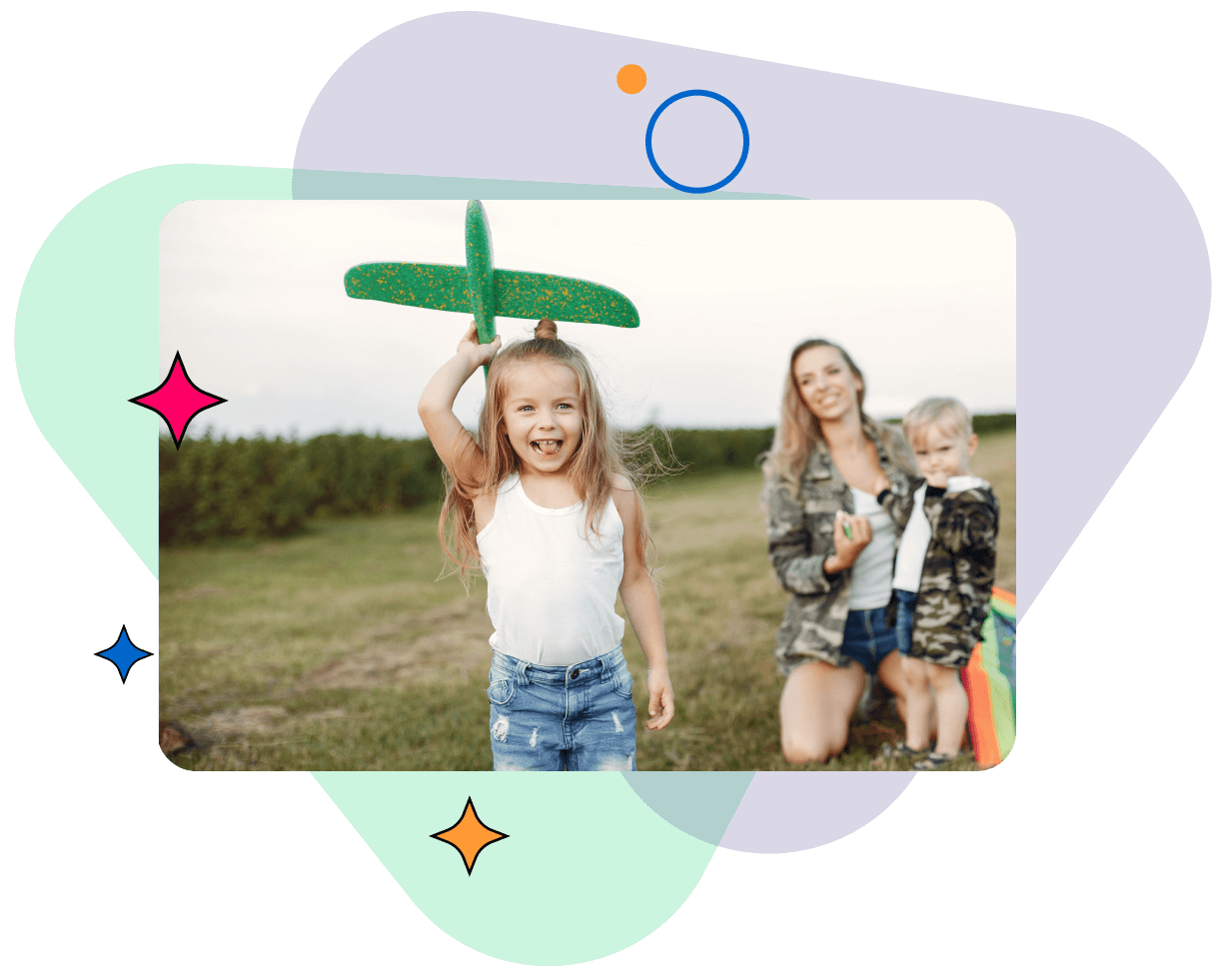 young_girl_holding_a_toy_plane_with_her_mom_watching_her_in_the_background-1